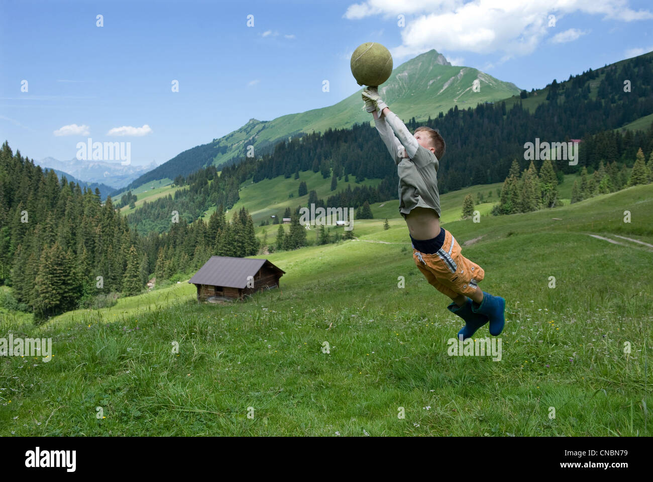 A boy playing with a ball, Blatti Alm, Switzerland Stock Photo