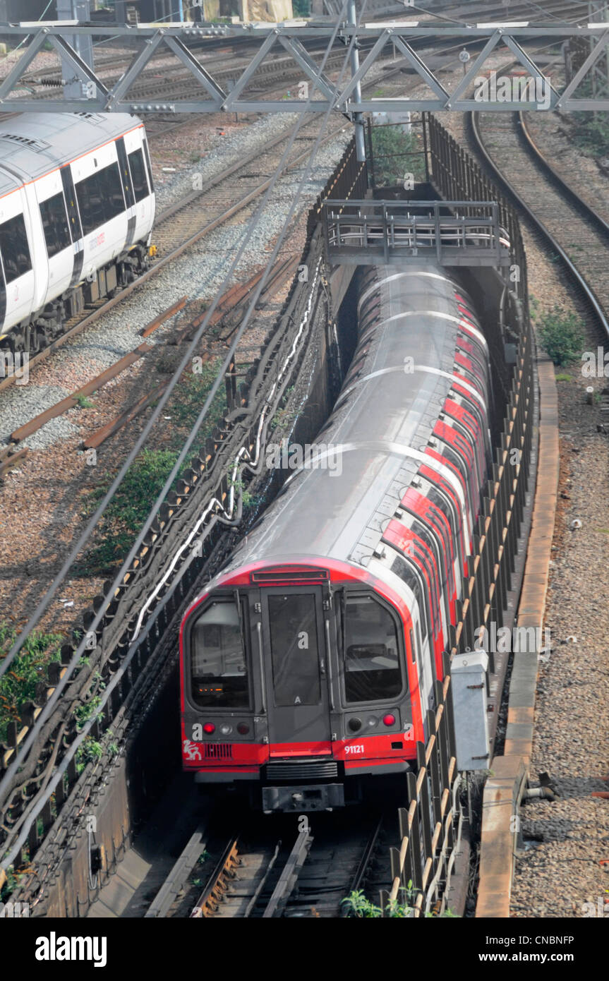 London underground tube train entering tunnel below overground train