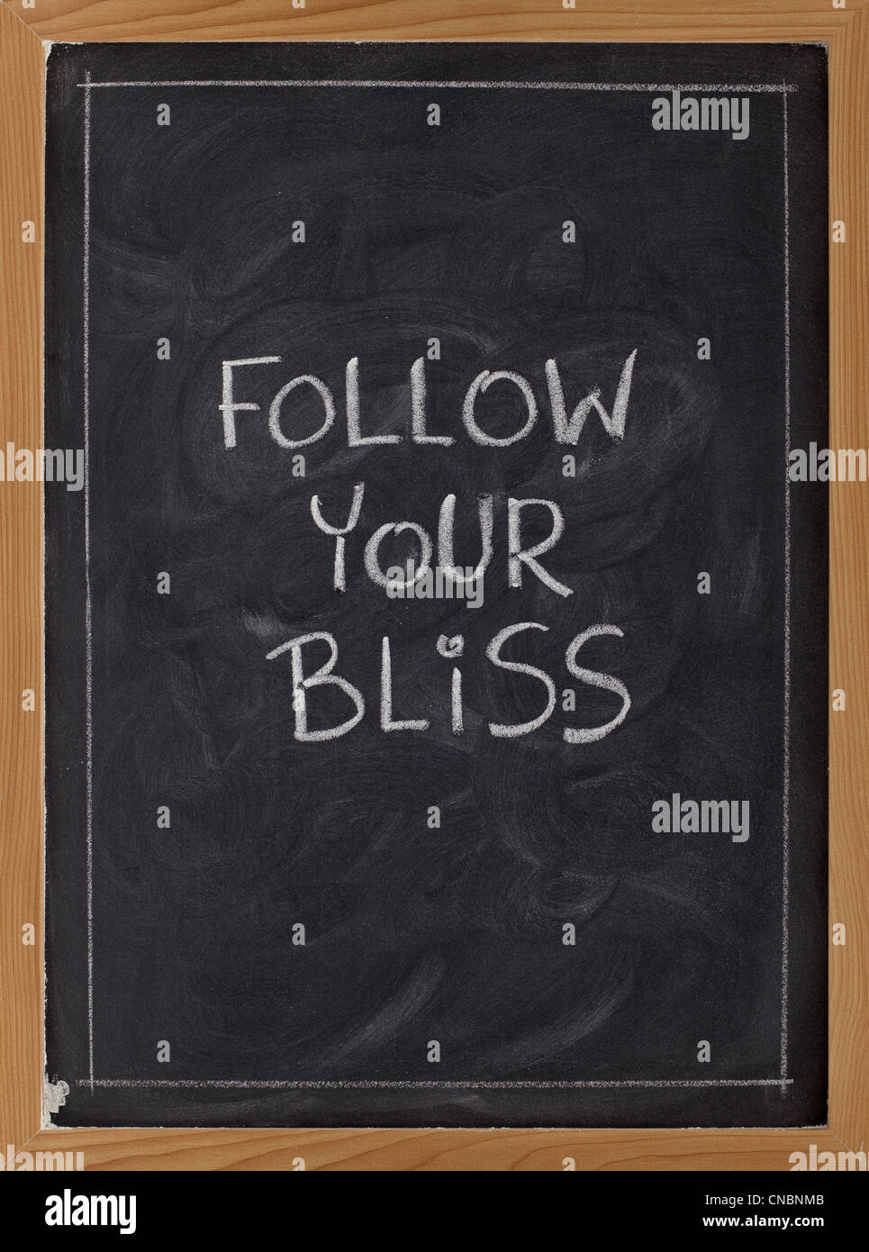 follow your bliss spiritual reminder - white chalk handwriting on a blackboard Stock Photo