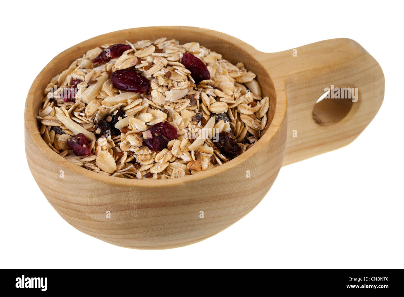 muesli cereal in (rolled oats with raisins, cranberries, slices almonds and flax seeds) on a rustic wooden scoop Stock Photo