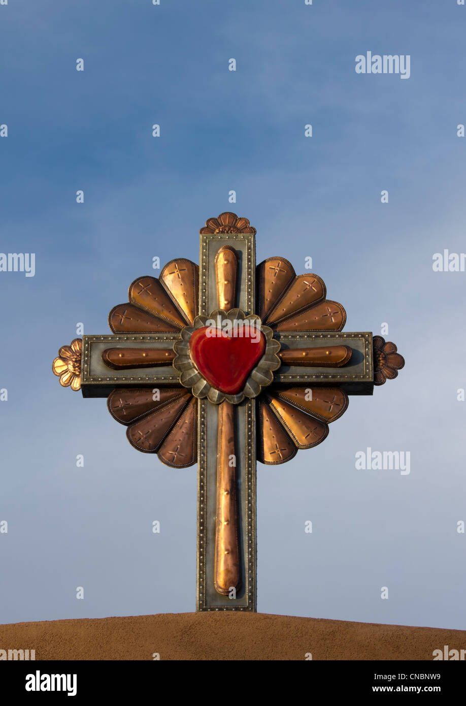 Guilded cross atop of a roman catholic church in Chimayo, New Mexico. Stock Photo