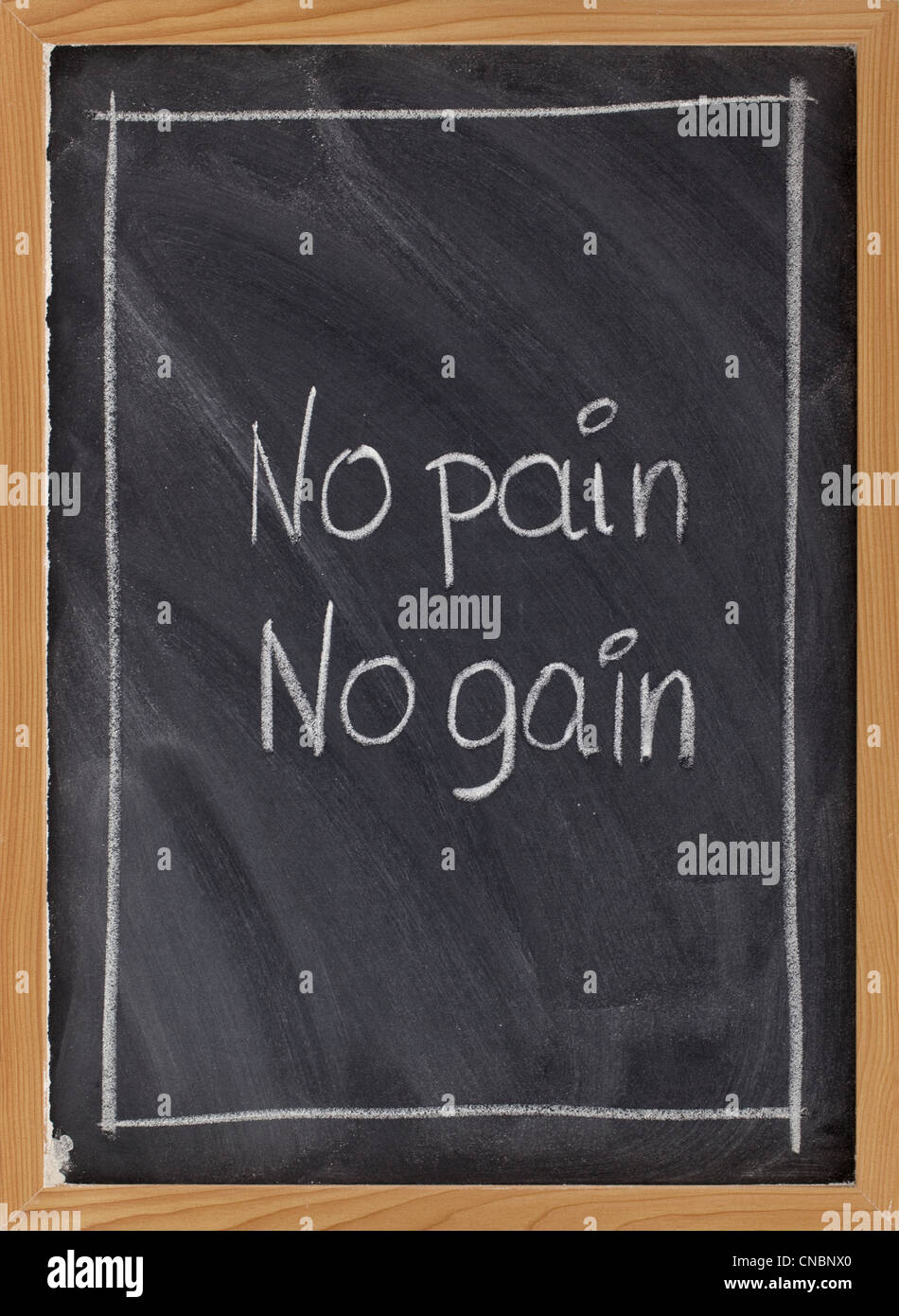 no pain, no gain - exercise, fitness, or coaching motto handwritten with white chalk on blackboard with eraser texture Stock Photo