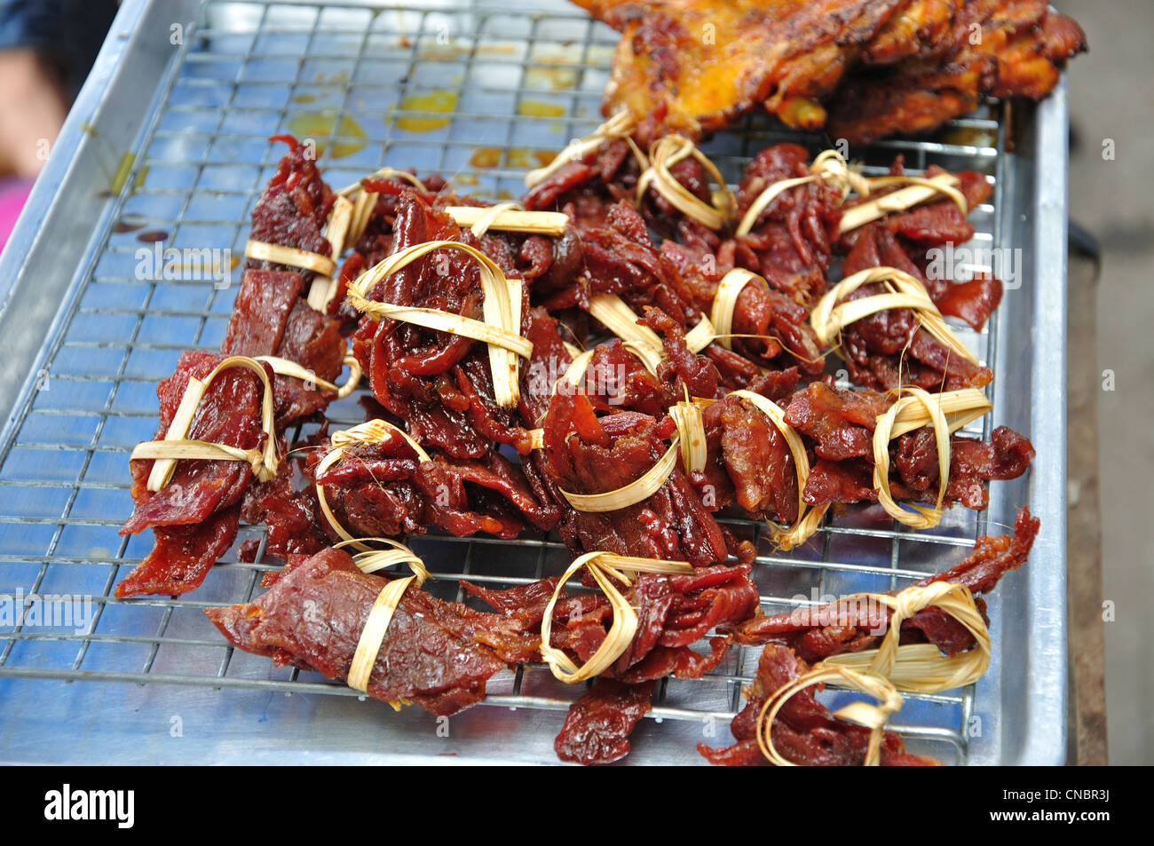 Cooked meat parcels on street stall, Tikathananon Road, Udon Thani, Udon Thani Province, Thailand Stock Photo