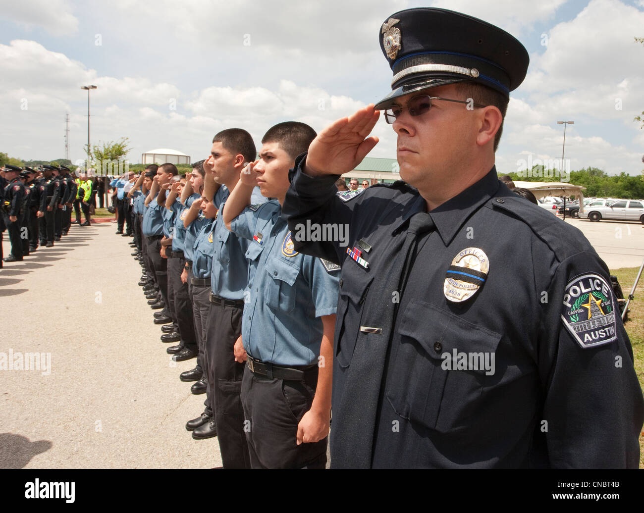 Officers salute during funeral for Austin Police Officer Jaime Padron, who was killed in the line of duty in a full ceremony Stock Photo