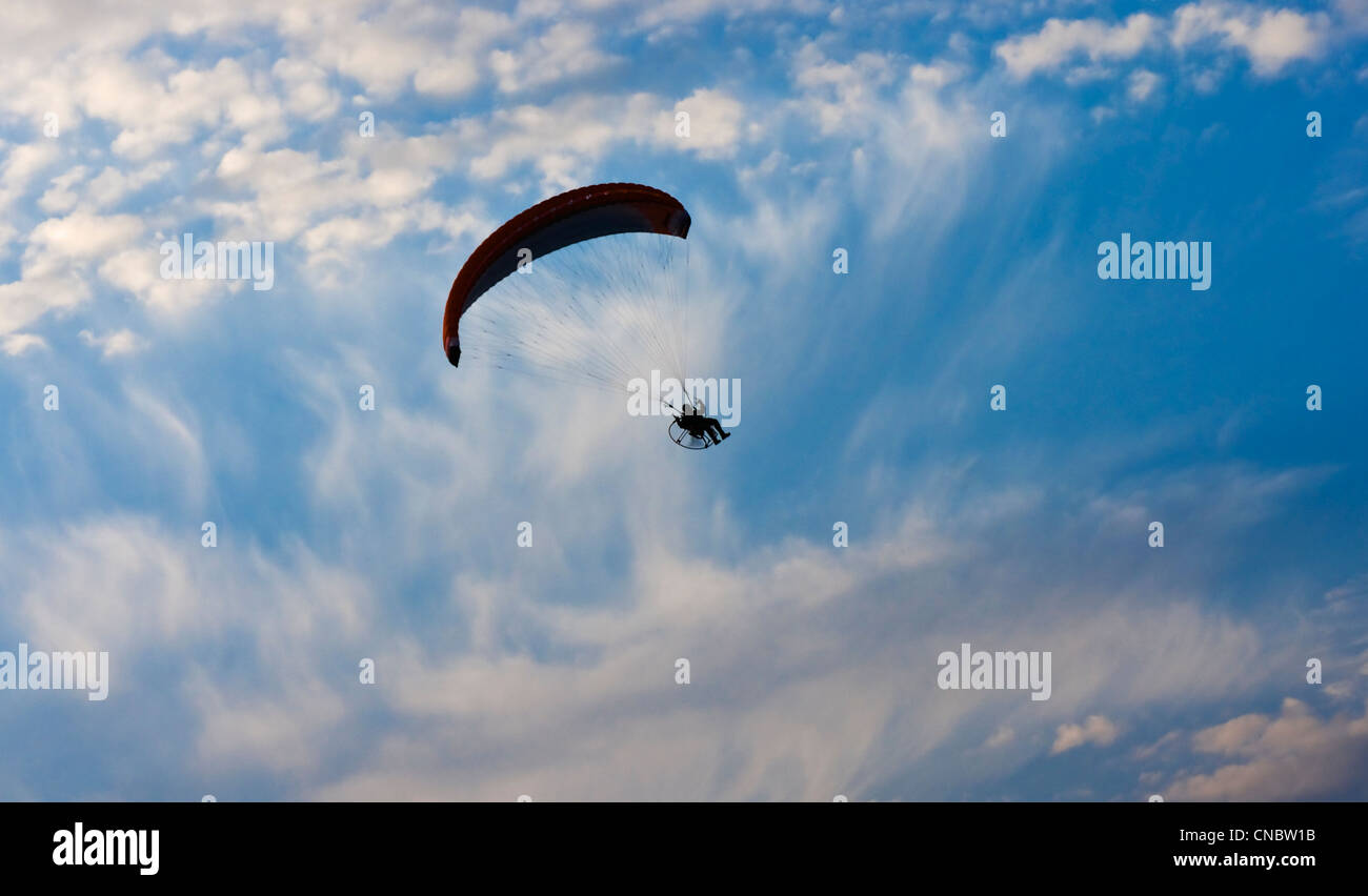 Clear blue sky with white clouds and lone paraglider. Stock Photo
