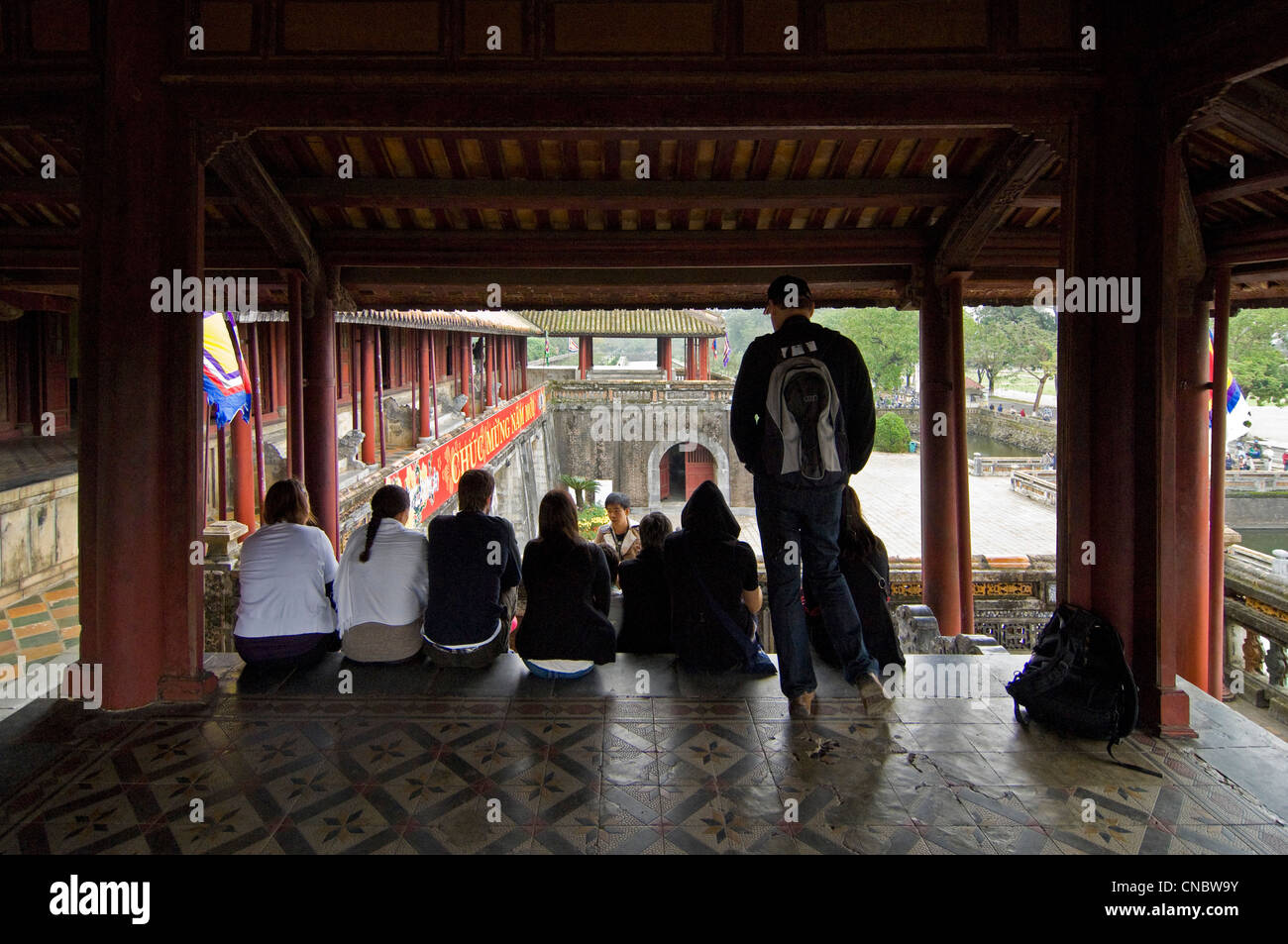Horizontal view of a guide with tourist group sitting in the Lau Ngu Phung, Five-Phoenix Pavilion at the Imperial Palace in Hue, Vietnam Stock Photo