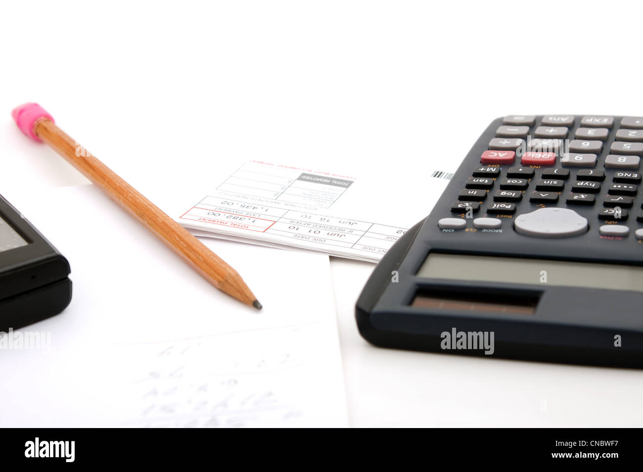 Adding up the monthly expenses for household accounting. A calculator pencil and paperwork. isolated over white. Stock Photo