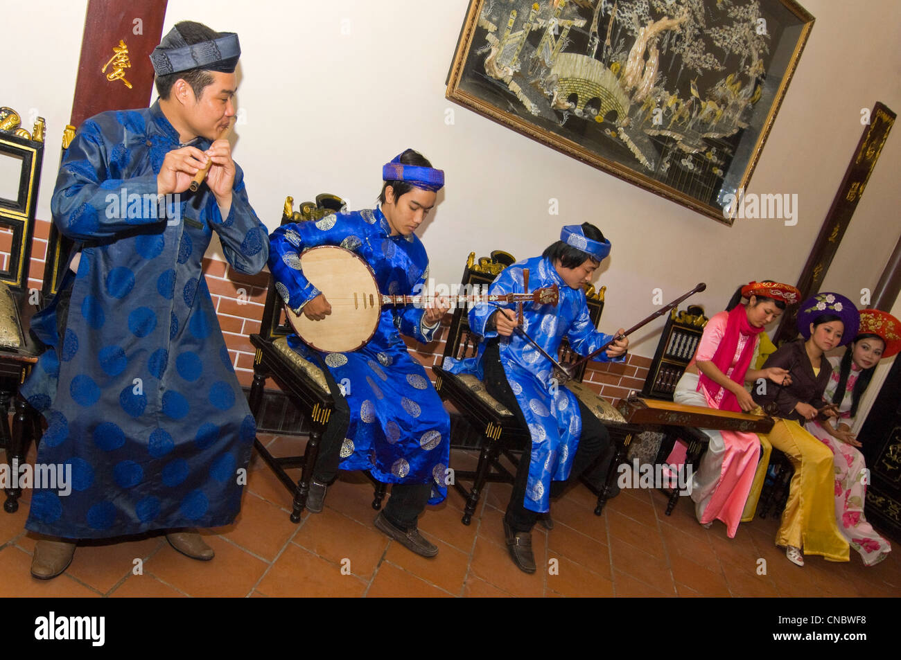 Horizontal view of a traditional Vietnamese troupe of musicians playing and singing traditional folklore songs in costume. Stock Photo