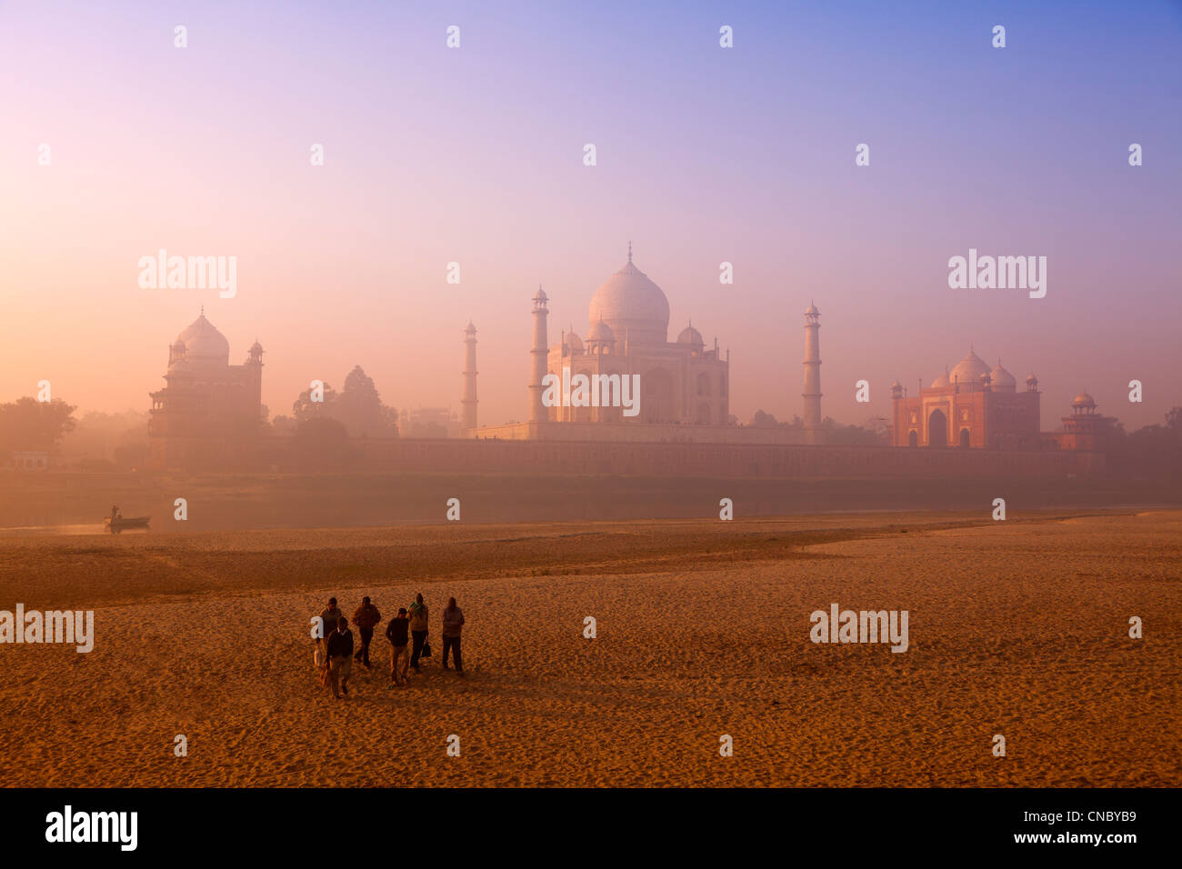 India, Uttar Pradesh, Agra, Taj Mahal workers crossing dried up Yamuna river at sunrise Stock Photo