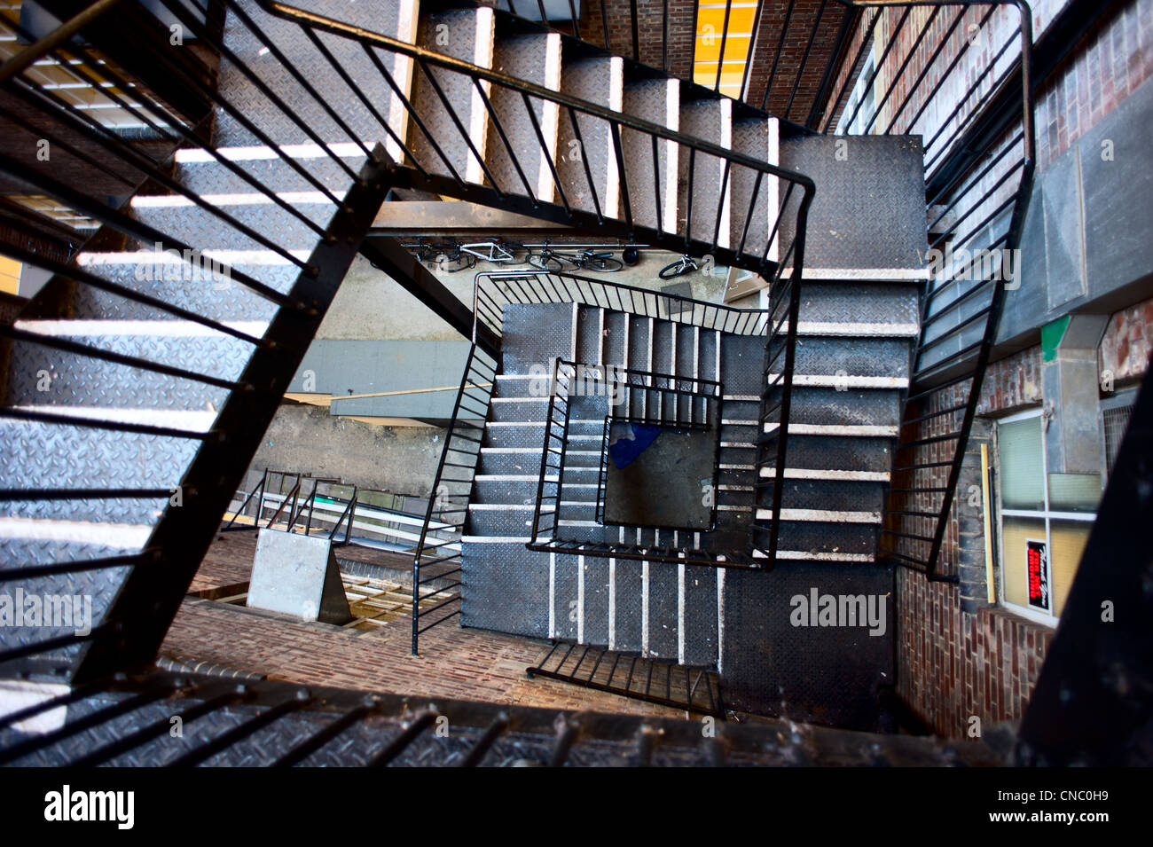 Wide angled photograph of an emergency ire exit staircase made of iron. The stairs are located behind an industrial building in London England. Stock Photo