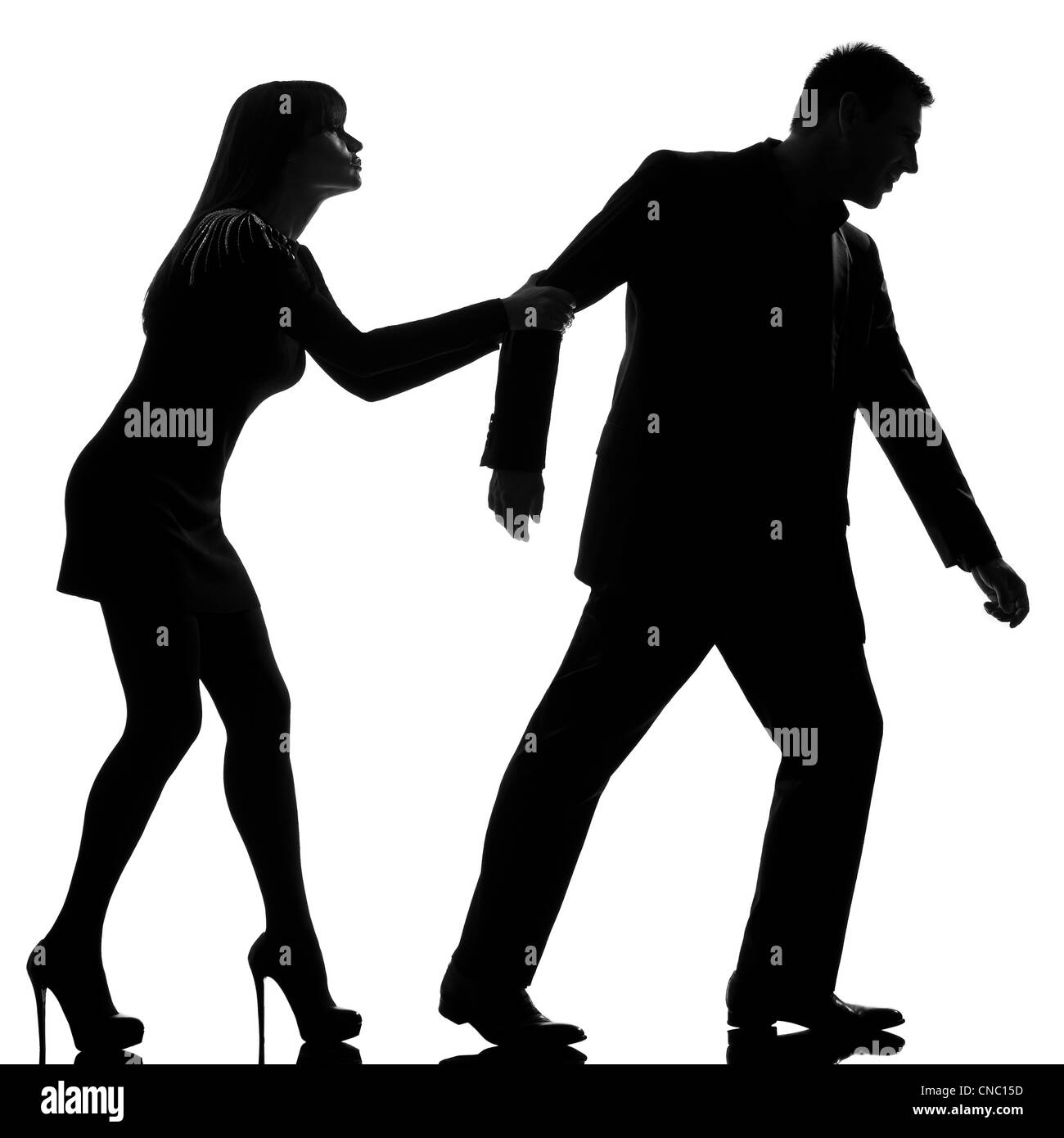 one caucasian couple dispute separation man leaving and woman holding back in studio silhouette isolated on white background Stock Photo