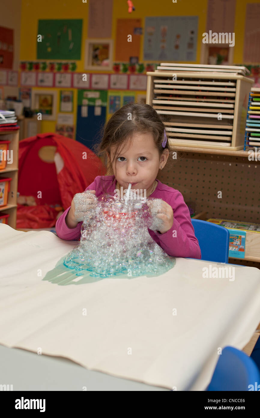 Preschool girl in the classroom blowing bubbles Stock Photo Alamy
