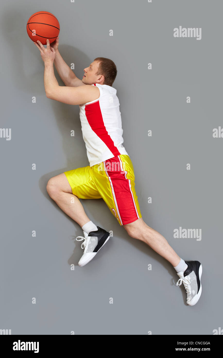 Muscular basketball player slamming the ball, overview Stock Photo Alamy