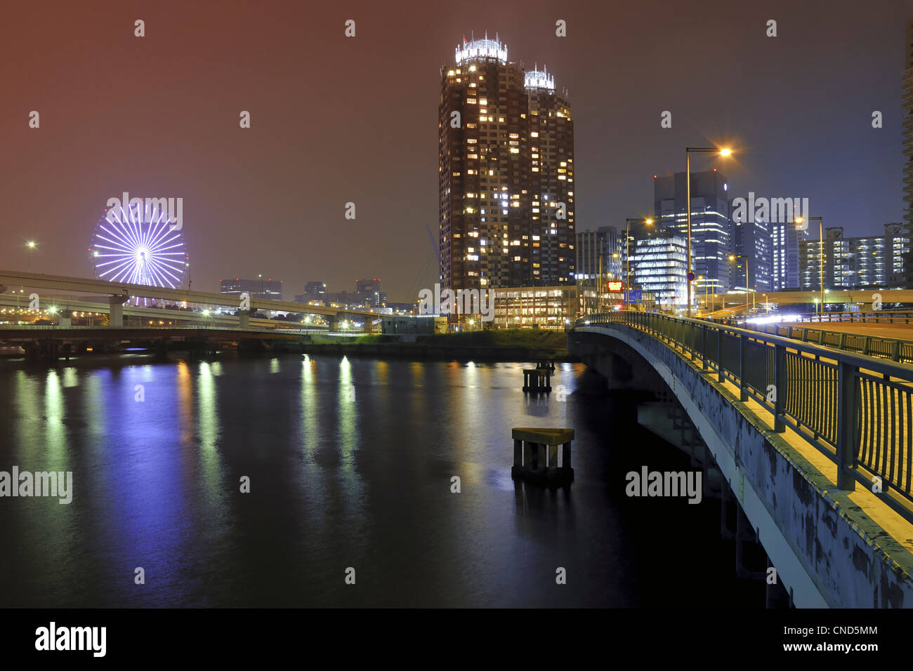 modern city well illuminated by night with scenic water reflection Stock Photo