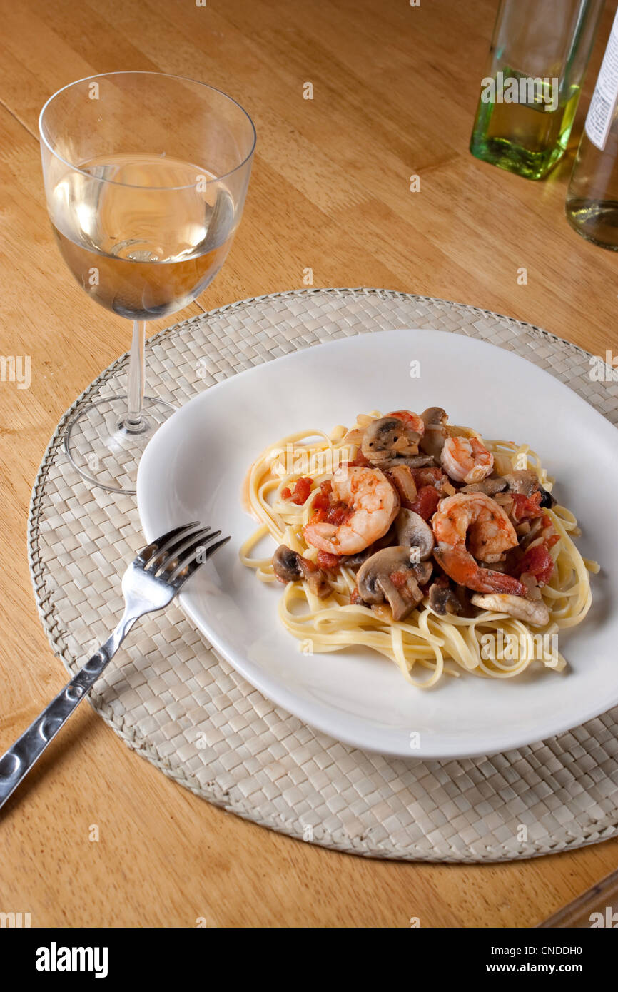 A delicious shrimp with linguine pasta dish and a nice glass of pinot grigio white wine. Stock Photo