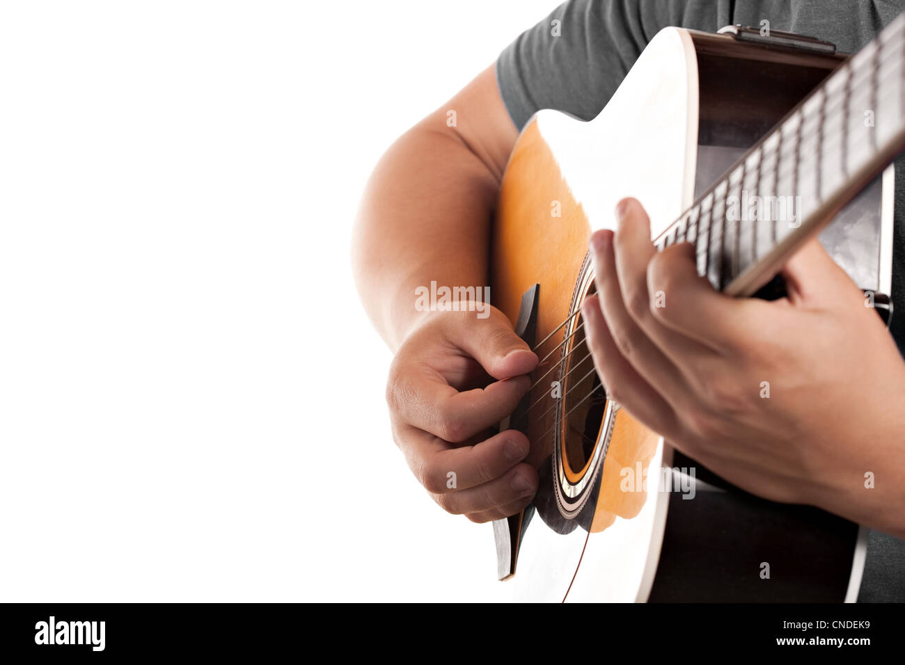 Closeup of a mans hands strumming and electric acoustic guitar isolated over a white background. Stock Photo