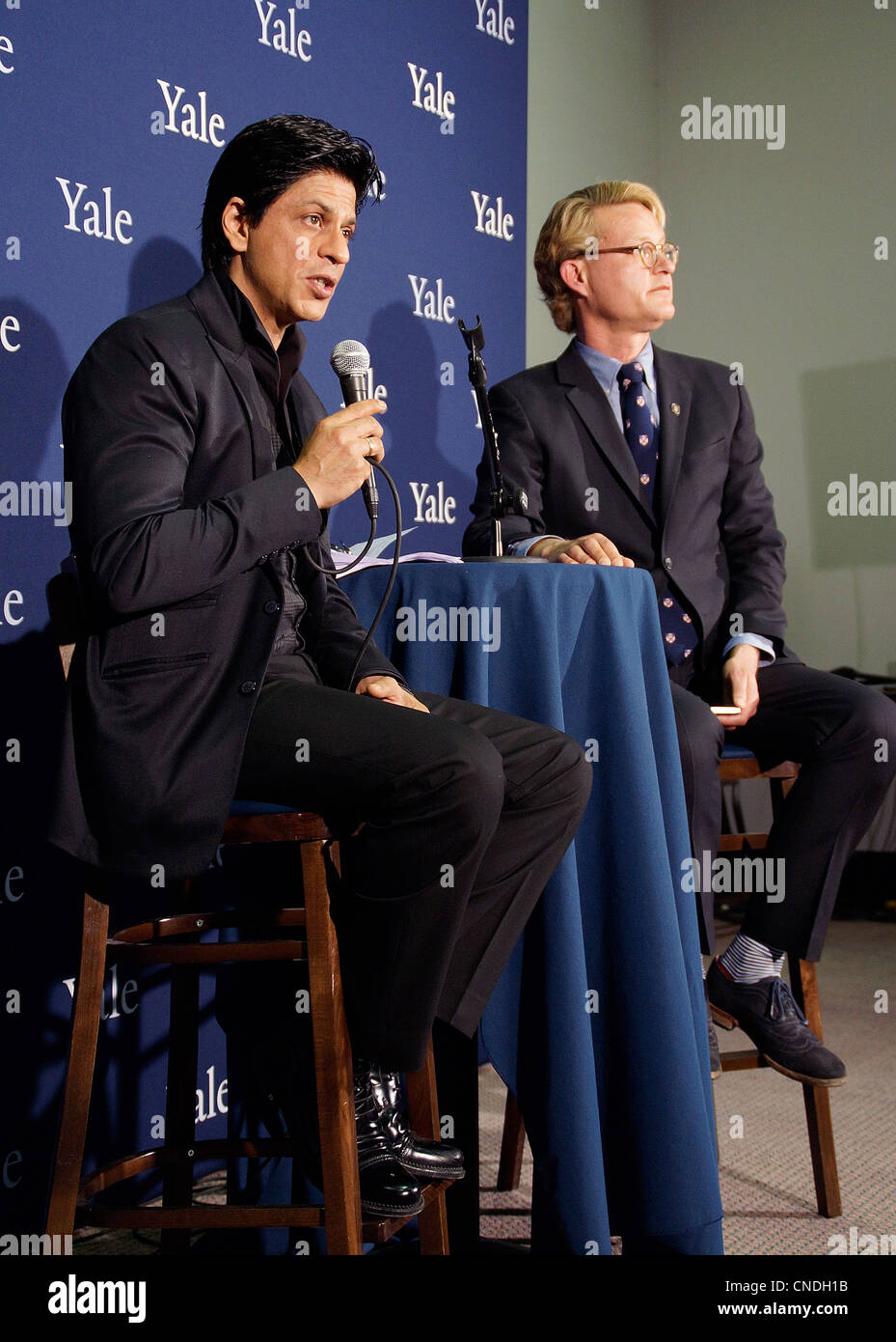 New Haven, CT USA-- Bollywood film superstar Shah Rukh Khan, left, along with Michael Morand of Yale, answers questions from the media during a press conference as he prepared to greet a packed house of fans at the Shubert Theater in New Haven. Shah Rukh Khan was receiving the Chubb Fellowship from Yale University. Stock Photo
