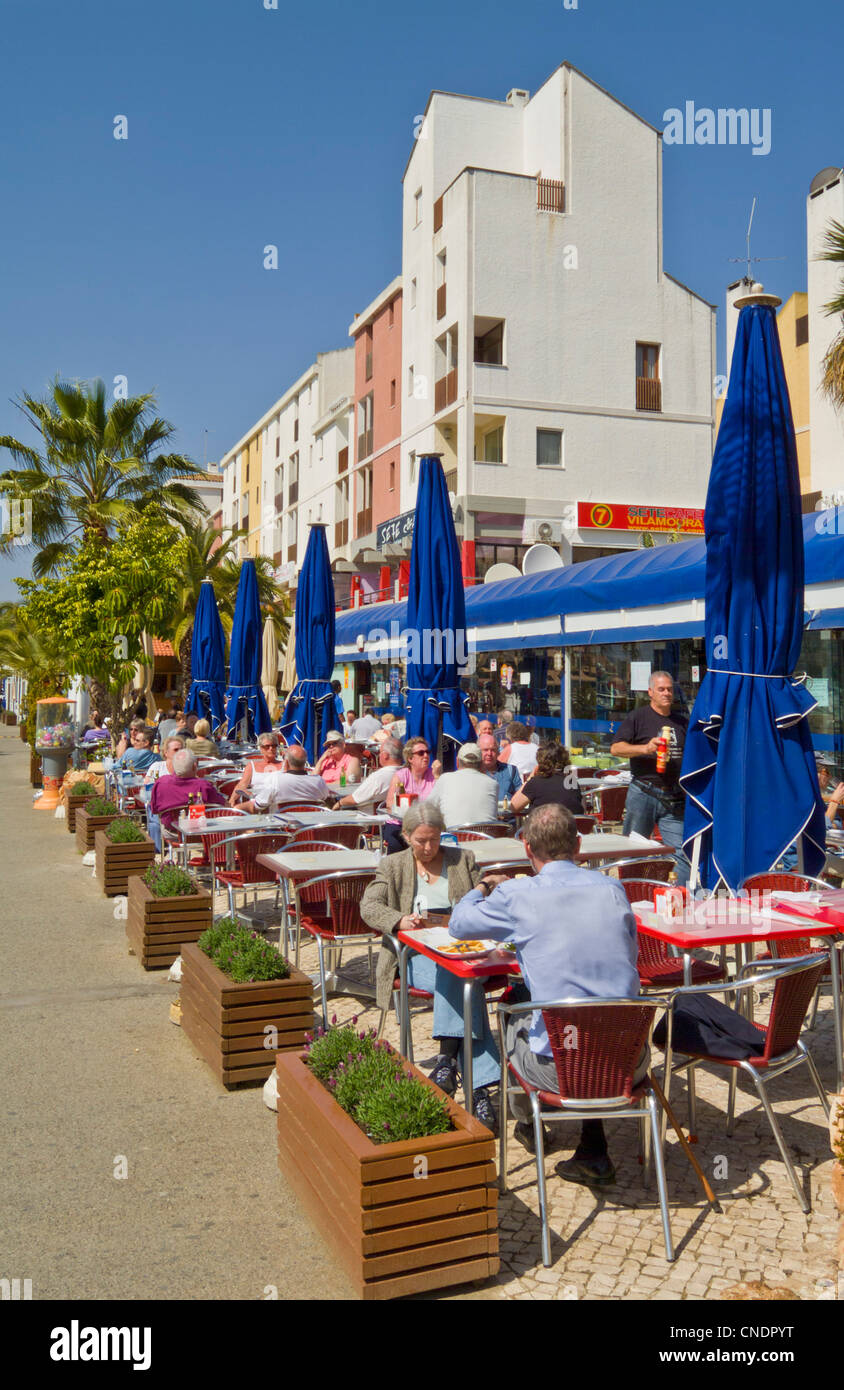 Diners in a cafe restaurant in the busy marina complex at Vilamoura Algarve Portugal EU Europe Stock Photo