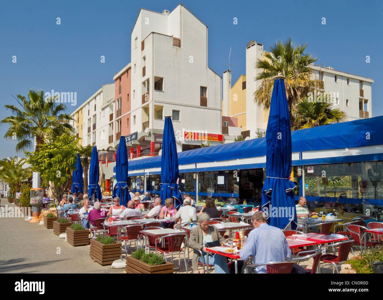 Diners in a cafe restaurant in the busy marina complex at Vilamoura Algarve Portugal EU Europe Stock Photo