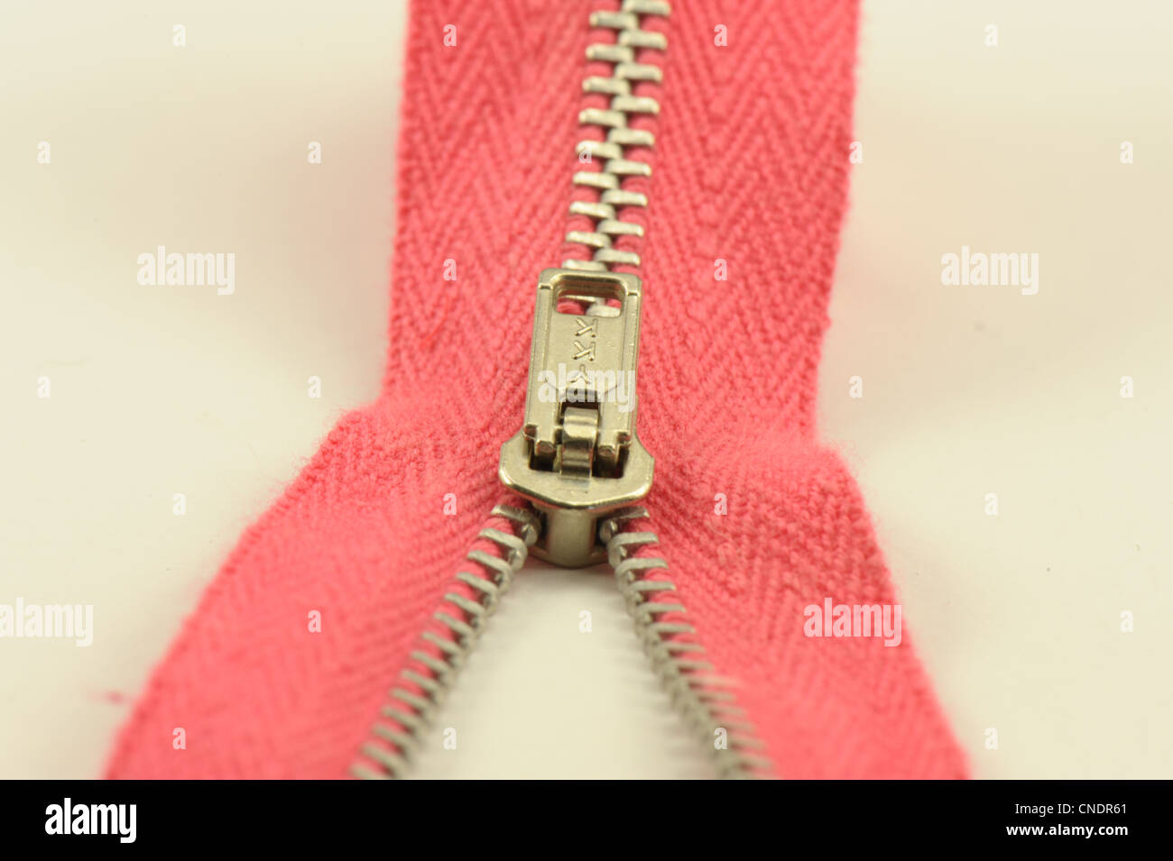 zip zipper red showing toggle taken on a white background sewing dressmaking Stock Photo