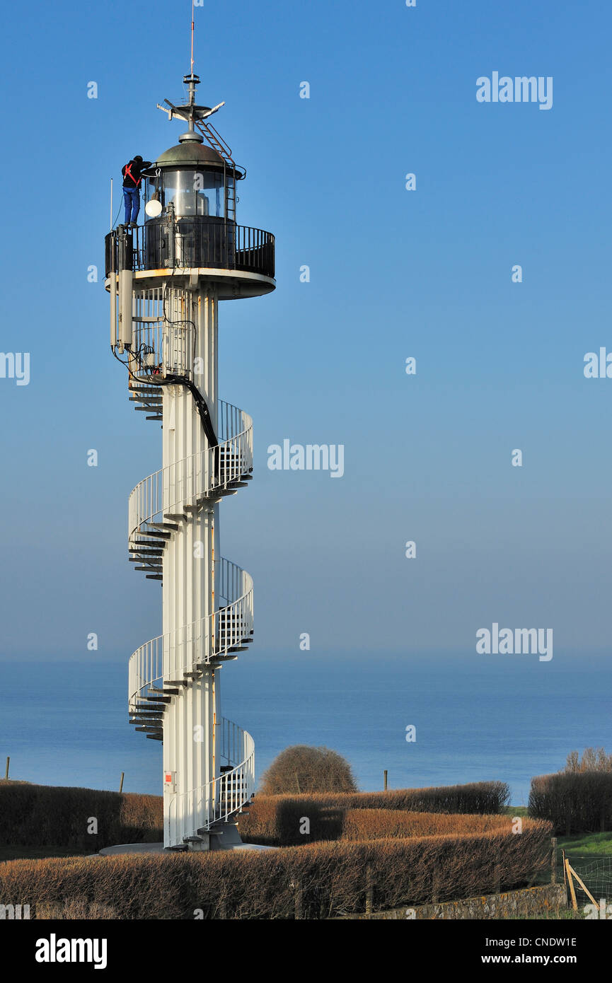 Worker doing maintenance work on the Alprech lighthouse with spiralling exterior staircase near