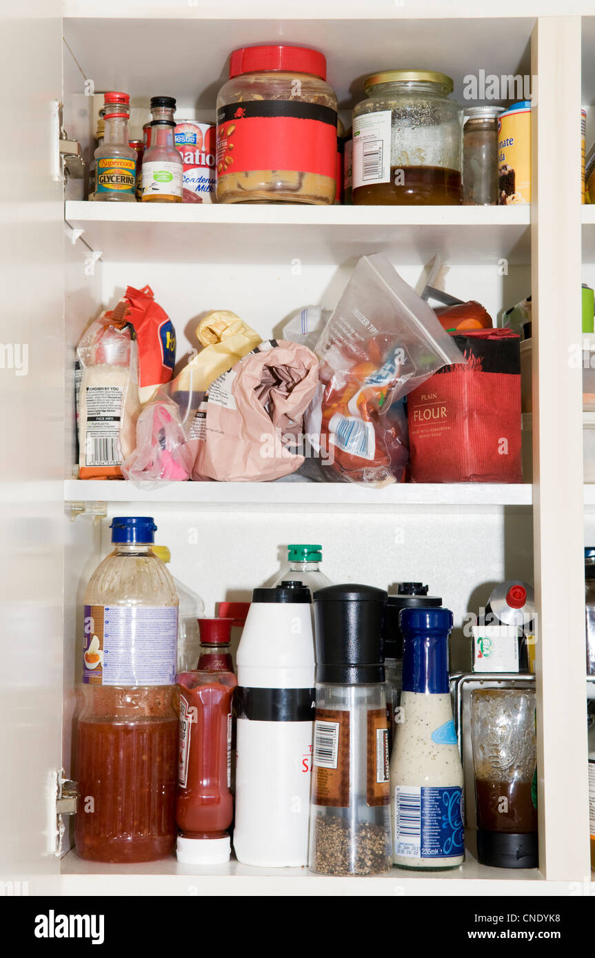 Kitchen cupboard contents showing cooking ingredients, food stuffs and condiments Stock Photo