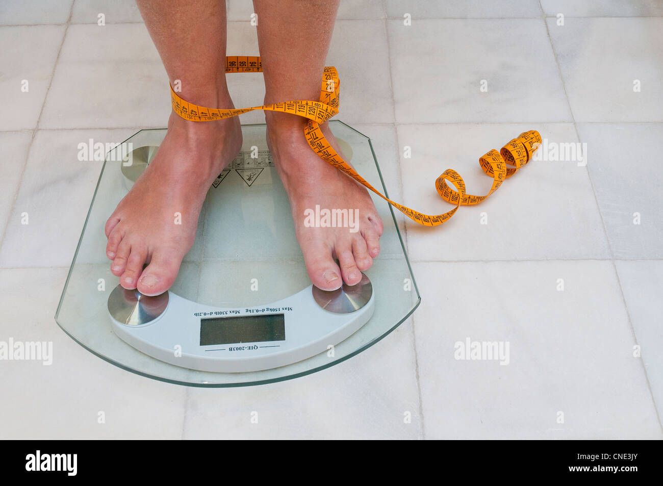 Mature woman weighing herself. Stock Photo