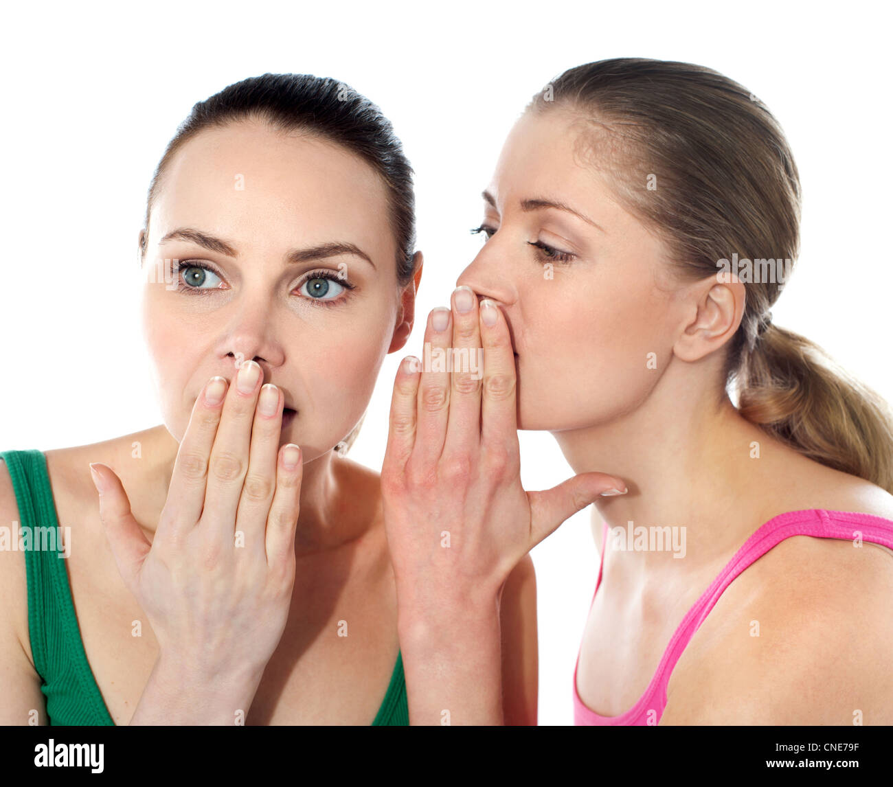 Two happy young girlfriends talking, gossips in secret Stock Photo