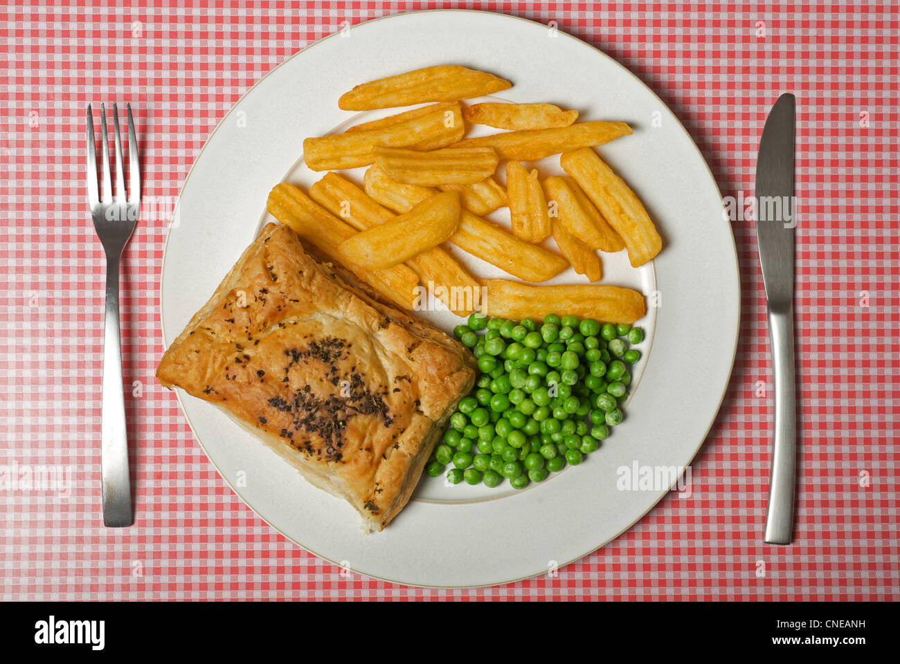 Salmon en croute (Waitrose own brand) oven chips and frozen peas Stock Photo