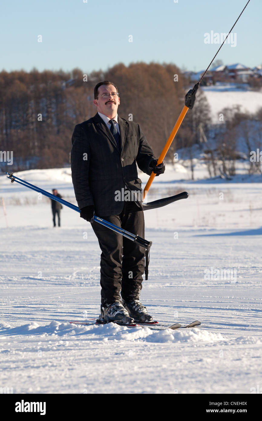 Man in business sute on ski lift Stock Photo