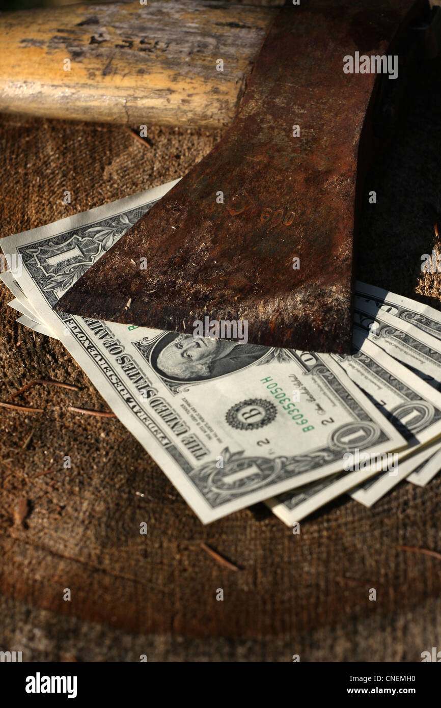 Four dollar bills under sharp old axe Stock Photo