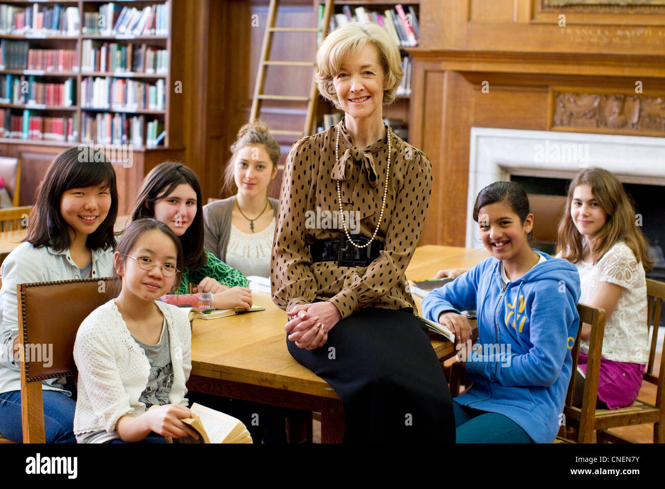 High Mistress, Clarissa Farr with pupils in the library of St Paul's Girls' School in Hammersmith, London, England, UK Stock Photo