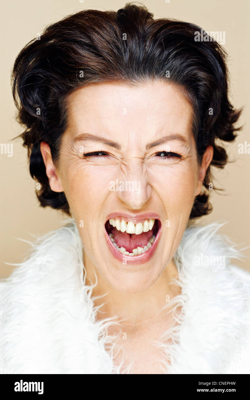 portrait of dark-haired woman in her forties shouting into camera Stock Photo