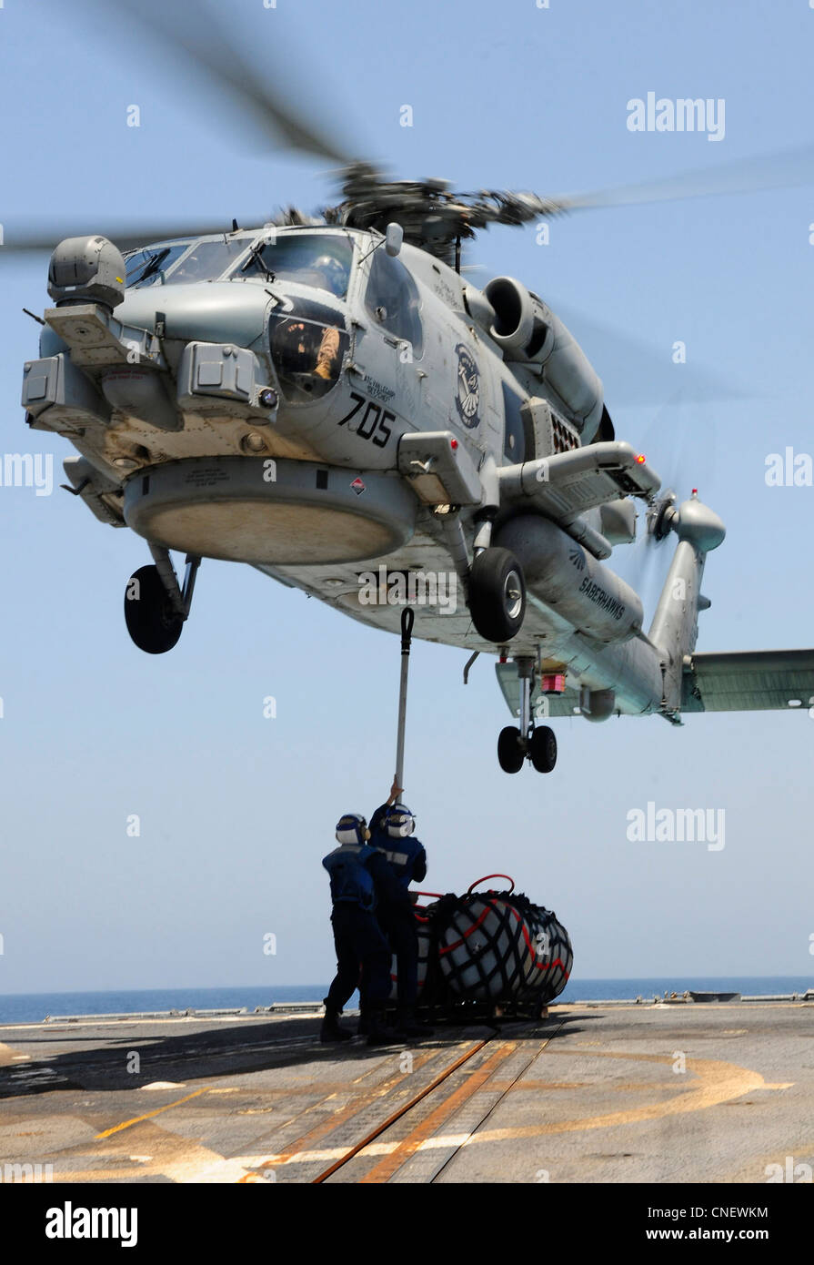 Sailors attach a cargo pallet to an MH-60R Sea Hawk helicopter assigned to the Saberhawks of Helicopter Maritime Strike Squadron 77 during replenishment at sea preparations aboard the Arleigh Burke-class guided-missile destroyer USS Sterett (DDG 104). Sterett is deployed as part of the Abraham Lincoln Carrier Strike Group to the U.S. 5th Fleet area of responsibility conducting maritime security operations, theater security cooperation efforts and support missions as part of Operation Enduring Freedom. ( Stock Photo