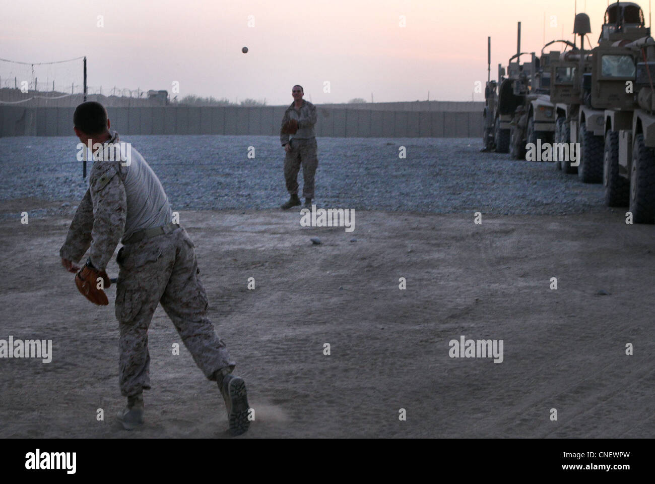 U.S. Marine Lance Cpl. Jake Black, a native of Ohio, and Navy Petty Officer Ryan Hall, a native of Ocala, Fla., play catch during an overnight stop here April 4, 2012, while touring the 2nd Battalion, 9th Marine Regiment area of operations. The ballplayers are part of their battalion’s provisional security detail, who also share responsibilities with the battalion’s quick reaction force. Stock Photo