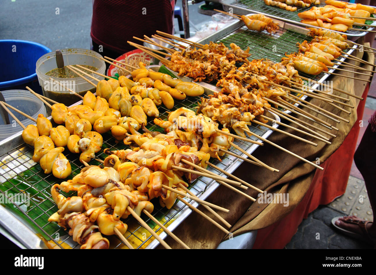 Meat and seafood skewers cooking on street stall, New Phetchaburi Road