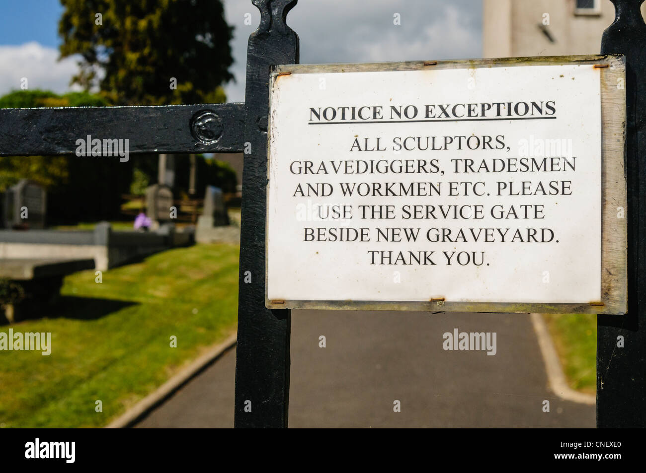 Sign at a cemetery calling on sculptors, gravediggers, tradesmen and workmen to use another gate Stock Photo
