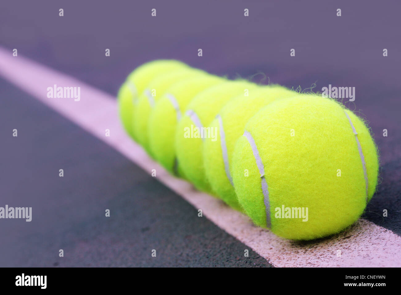 Tennis balls close up arranged in row on hard court synthetic tennis turf Stock Photo