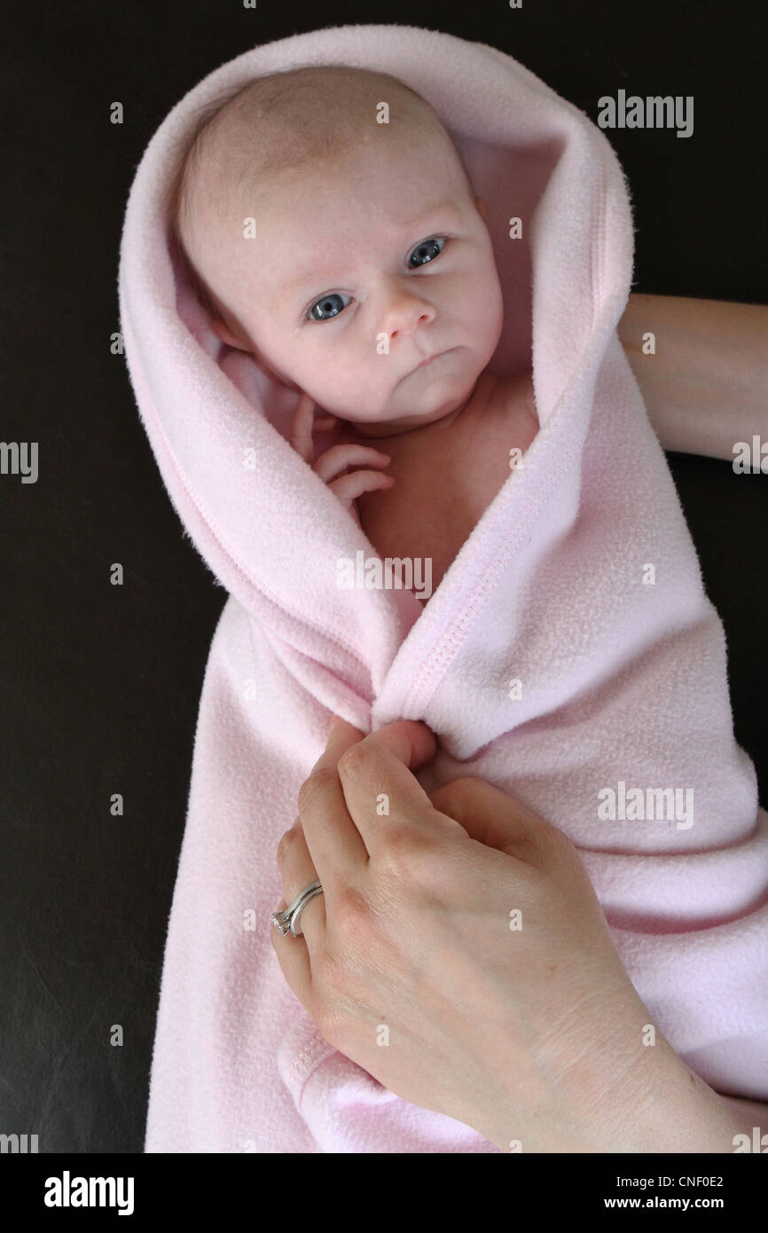 A newborn baby girl wrapped in a pink blanket being held Stock Photo Alamy
