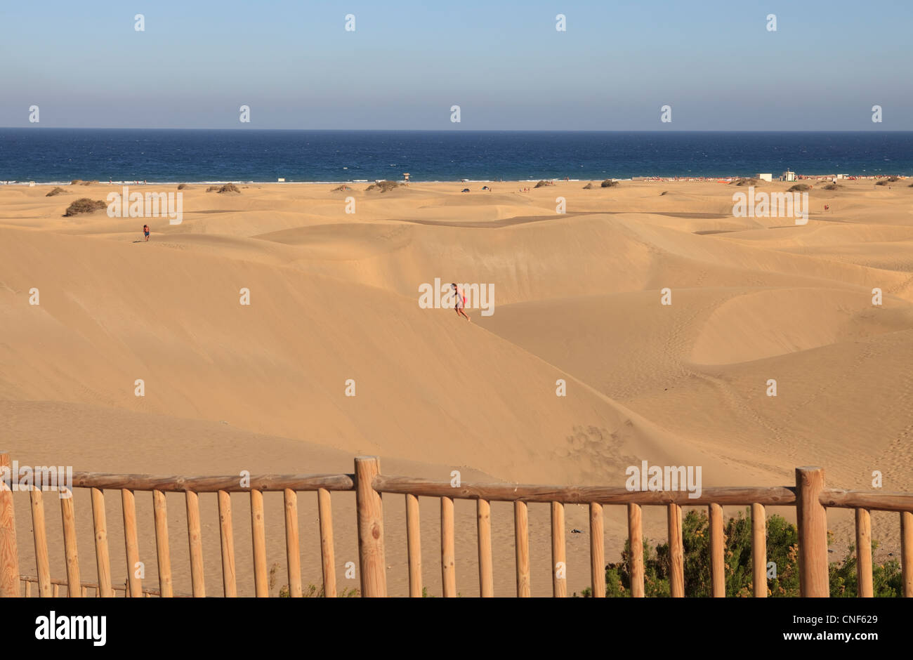 Man climbing the high sand dunes of Gran Canaria Stock Photo