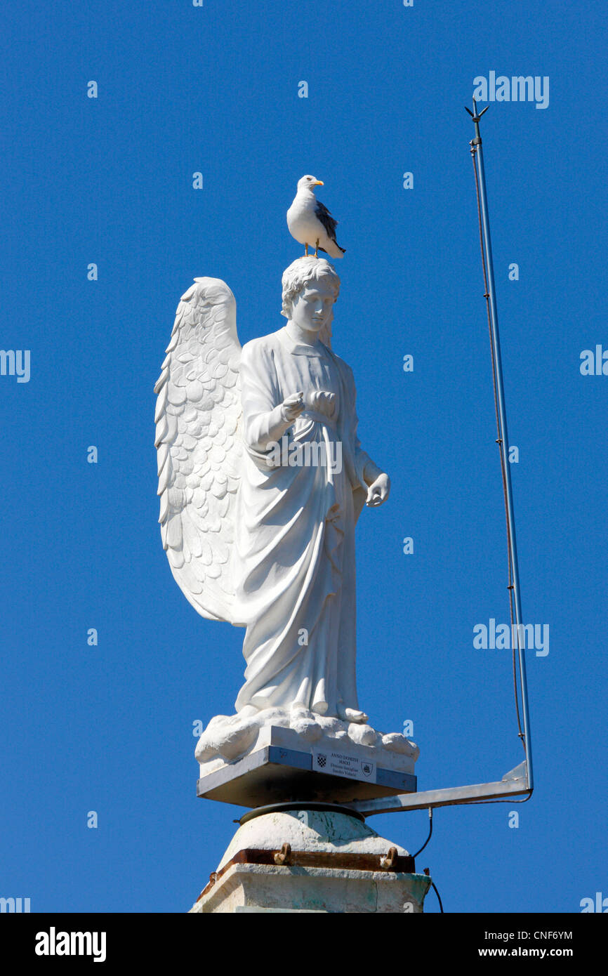 Close up of Angel statue on the top of church tower. Mali Losinj island in Croatia Stock Photo