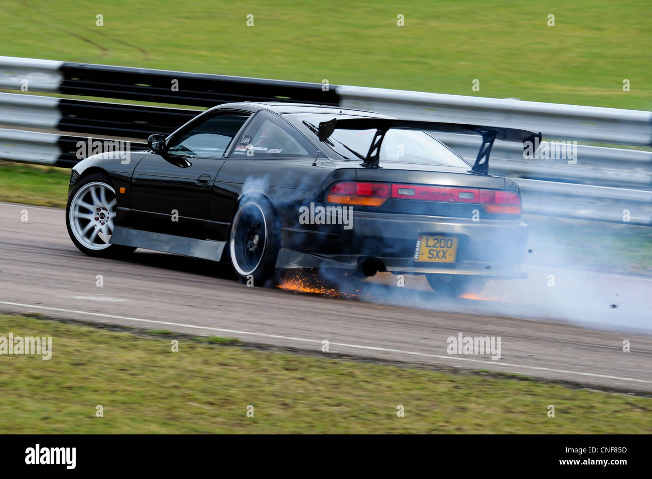 Car drifting at Lydden Hill Race Circuit Track Kent England Dover Smoking Sparks Flying Nissan 200SX Shredding Rubber Stock Photo