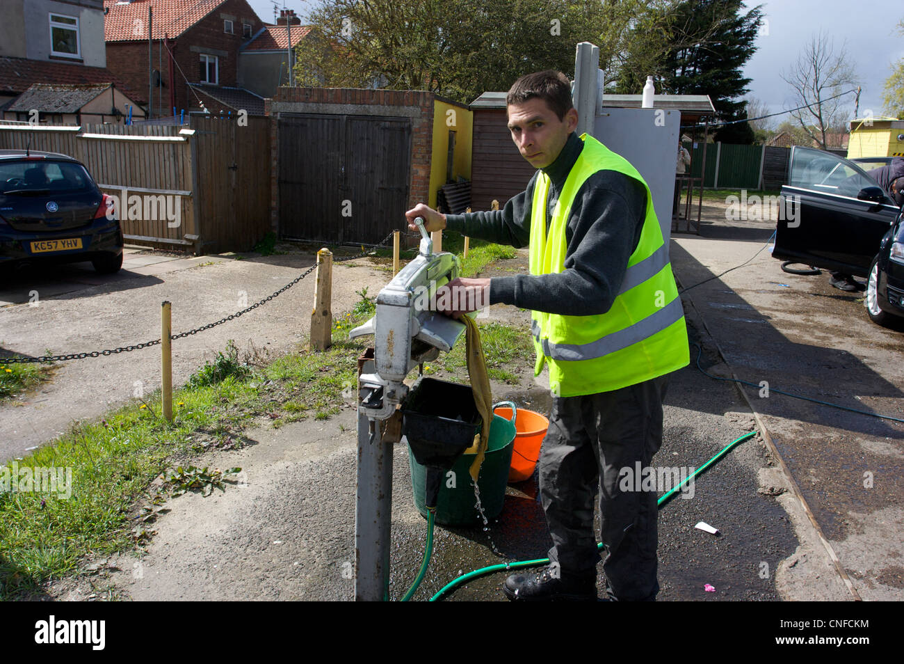 Car wash service, men drying cloth with HIVIZ waist coat, Norfolk, UK