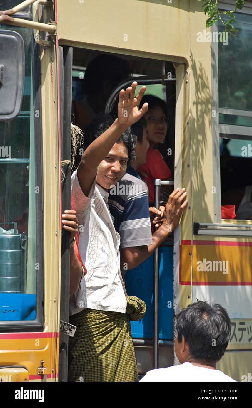 Burmese conductor at dor to a public bus. Mandalay, Burma. Myanmar Stock Photo