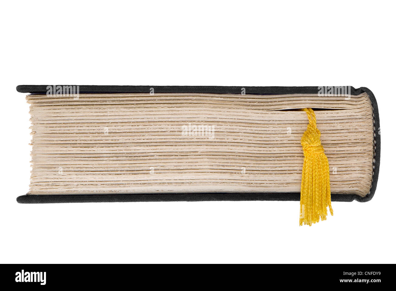 Top end view of closed hardcover book with roughly trimmed pages and golden tassels of a bookmark hanging down Stock Photo