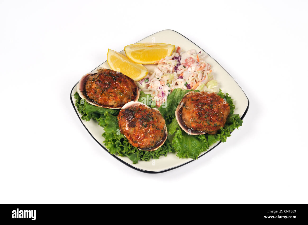 Plate of Cape Cod stuffed clams on lettuce  with breadcrumbs topping & cole slaw and lemons on the side Stock Photo