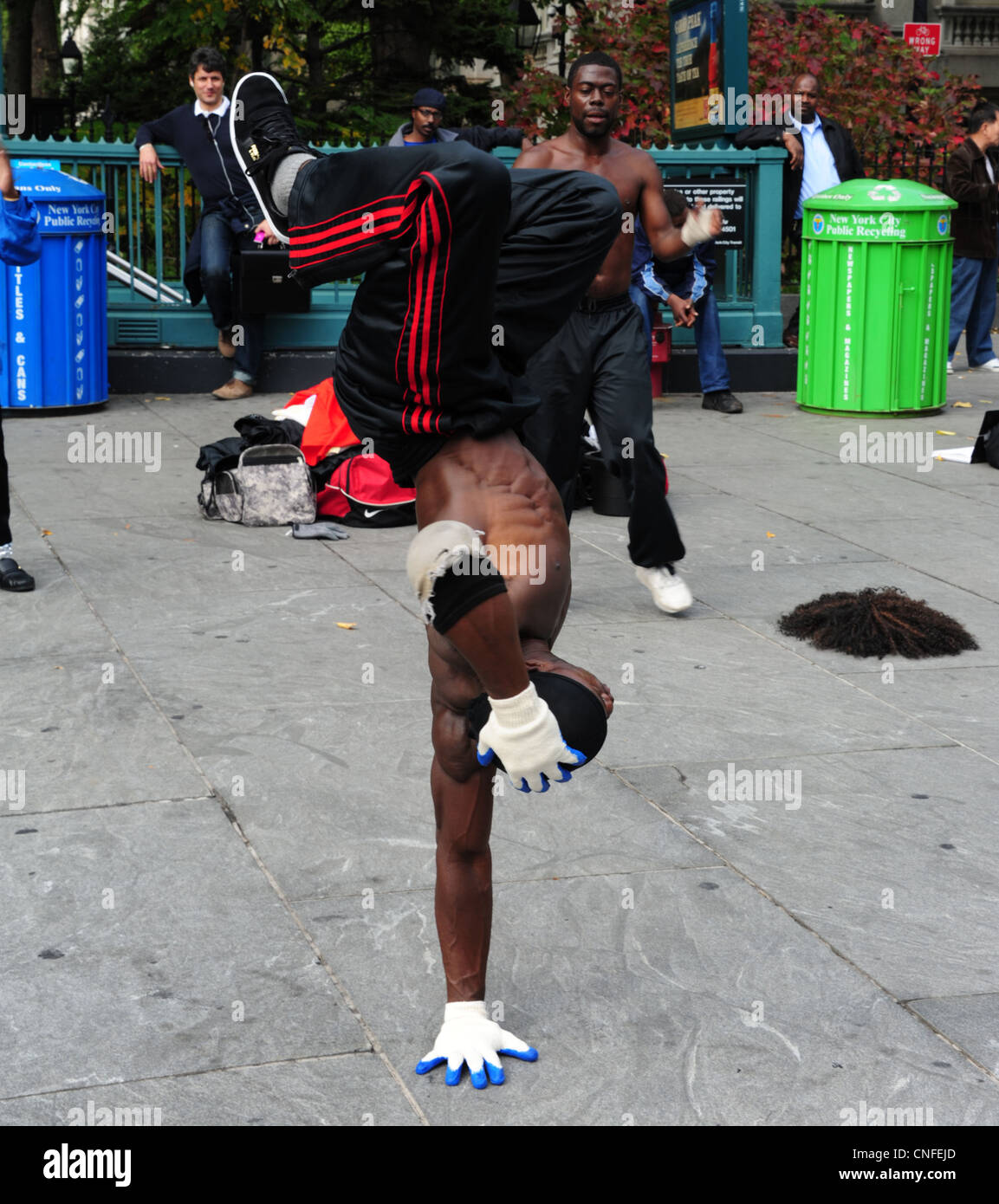 AfricanAmerican man, white gloves balancing one hand body upright