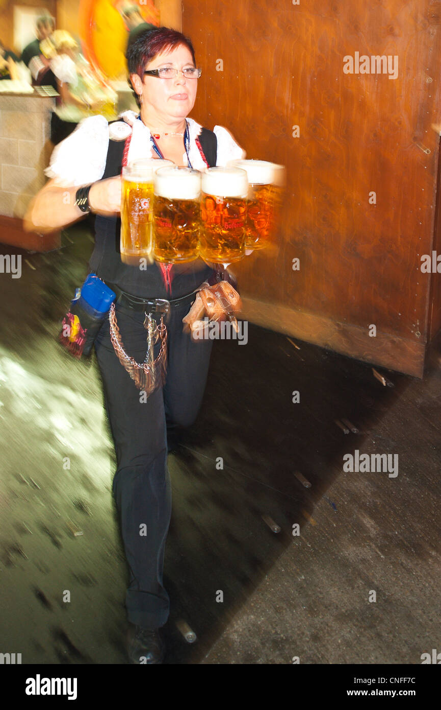 Woman serving beer glasses at the Stuttgart Beer Festival, Cannstatter Wasen, Stuttgart, Germany. Stock Photo