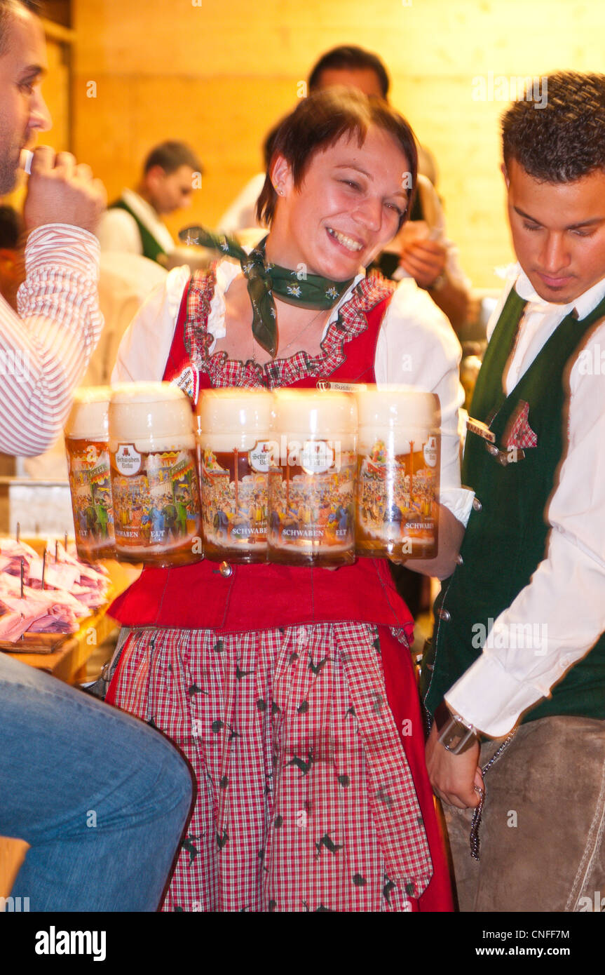 Woman maid maiden serving beer glasses at the Stuttgart Beer Festival, Cannstatter Wasen, Stuttgart, Germany. Stock Photo