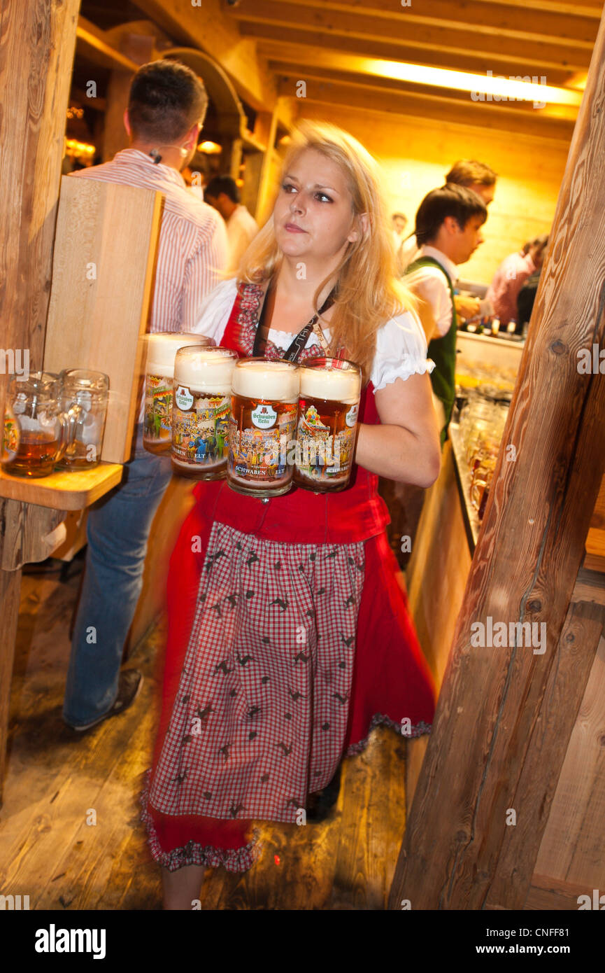 Woman serving beer glasses at the Stuttgart Beer Festival, Cannstatter Wasen, Stuttgart, Germany. Stock Photo
